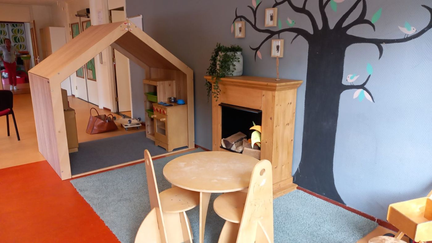 Speelhoek met houten huisje en boomschildering op locatie Breehorn